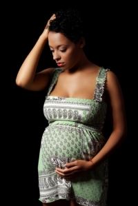 Pregnant Woman Holding Her Head With One Hand and Belly With the Other