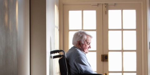 elderly patient in wheelchair looking melancholy