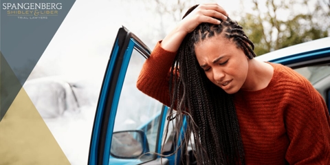 woman holding her head after a car accident