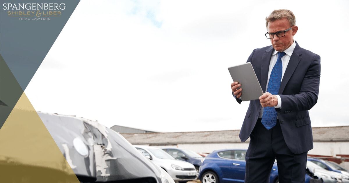 insurance adjuster documenting damage on a vehicle