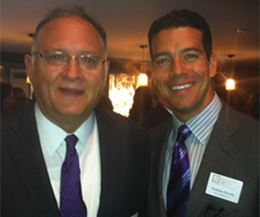 Two Men in Suits, Smiling and Standing Close Together at an Event