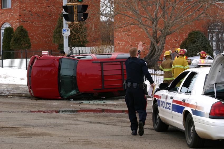 Police and Firemen at the Scene of a Rolled Vehicle in the Snow